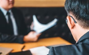 Senior manager reading a resume during a job interview employee young man meeting Applicant and recruitment concept