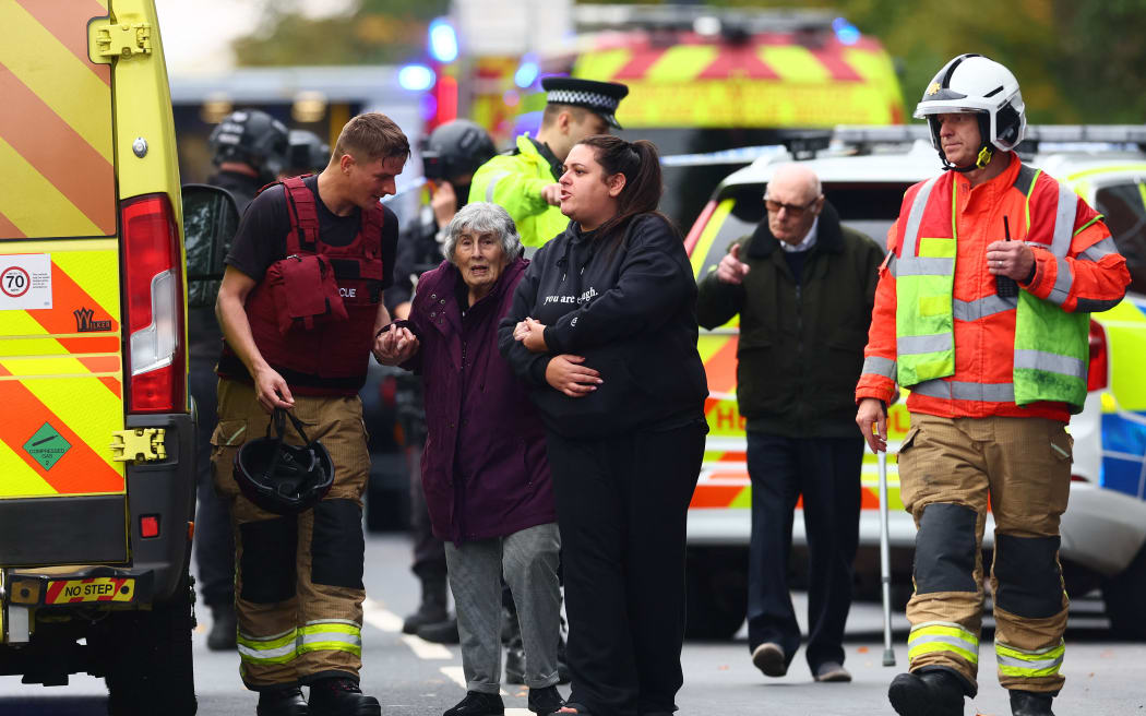 Members of the emergency services evacuate members of the community near Heaton Park Hebrew Congregation synagogue in Crumpsall, north Manchester, on October 2, 2025, following a "major incident" at the synagogue. Four people were injured and a suspected perpetrator shot by police Thursday after and a car was driven towards people outside a synagogue in Manchester, northern England, and one person was stabbed, officials said. Greater Manchester Police declared a "major incident" shortly after 9:30am (0830 GMT) after officers were called to the Heaton Park Hebrew Congregation Synagogue in the Crumpsall neighbourhood of the city. (Photo by Paul Currie / AFP)