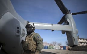 A Marine corps helicopter crew member waits as a helicopter lands at Musa Qala District centre base in Helmand province on January 27, 2011.