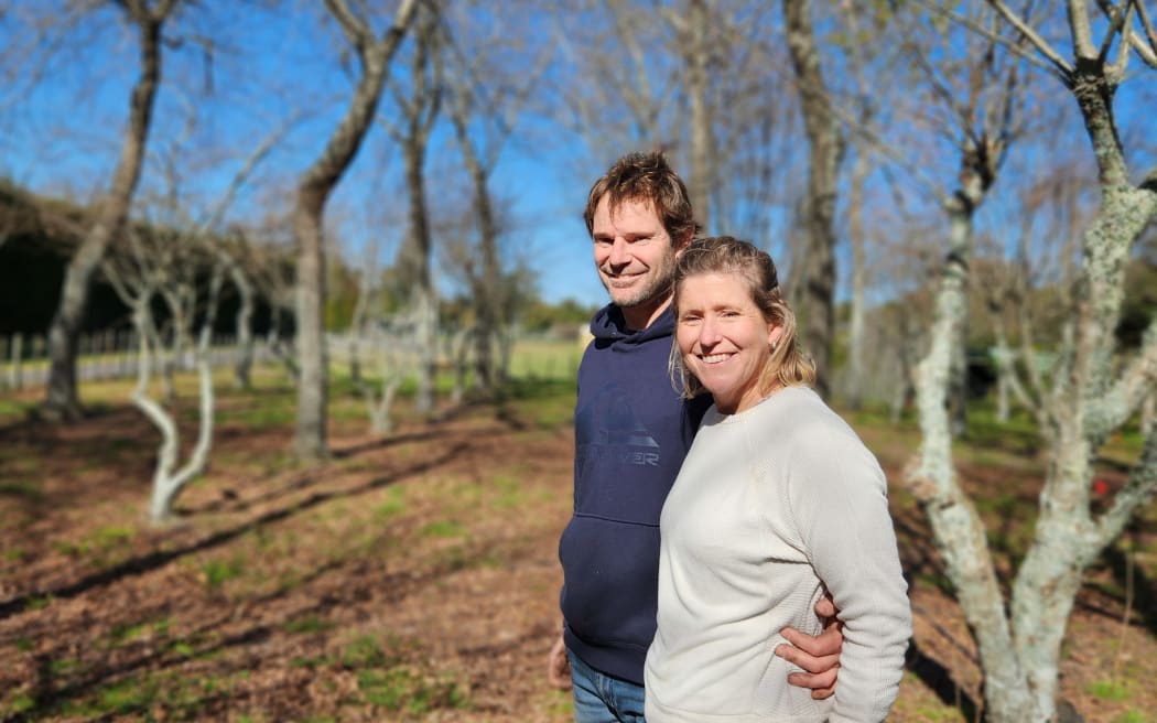 Lance and Nikki Dodd standing together against a backdrop of bare-leaved trees in their truffière
