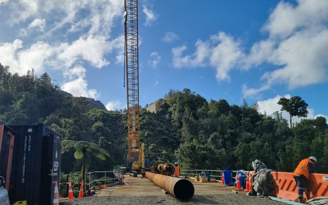 A 28 tonne crane preparing to place a pile from the staging bridge at the construction site of the 125m steel girder bridge.