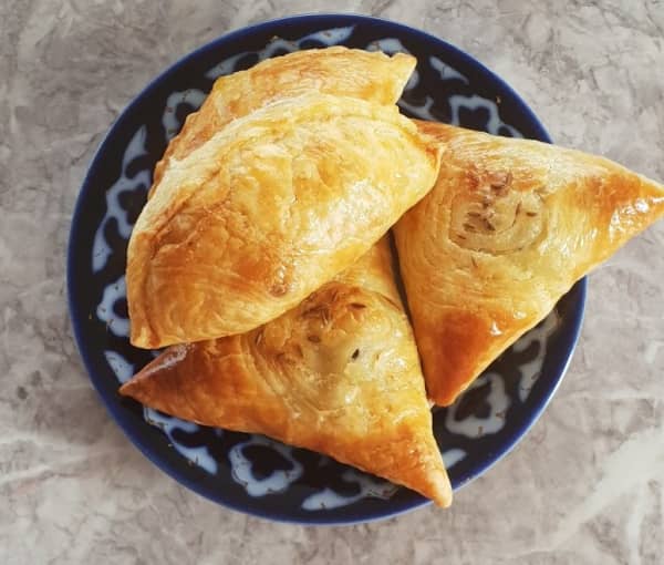 Butter filled pastry that's triangle-shaped in a plate.