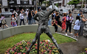 Fans gather in front of statue depicting Brazilian football legend Pele, in Santos, Brazil following his death in December 2022.