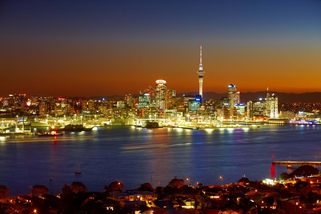 The Sky Tower and waterfront are lit by evening lights - as seen from Devonport on the North Shore.