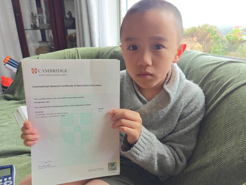 Raymond Hsu holding up his certificate - the first Cambridge grade he received for the International Mathematics exam in June last year.