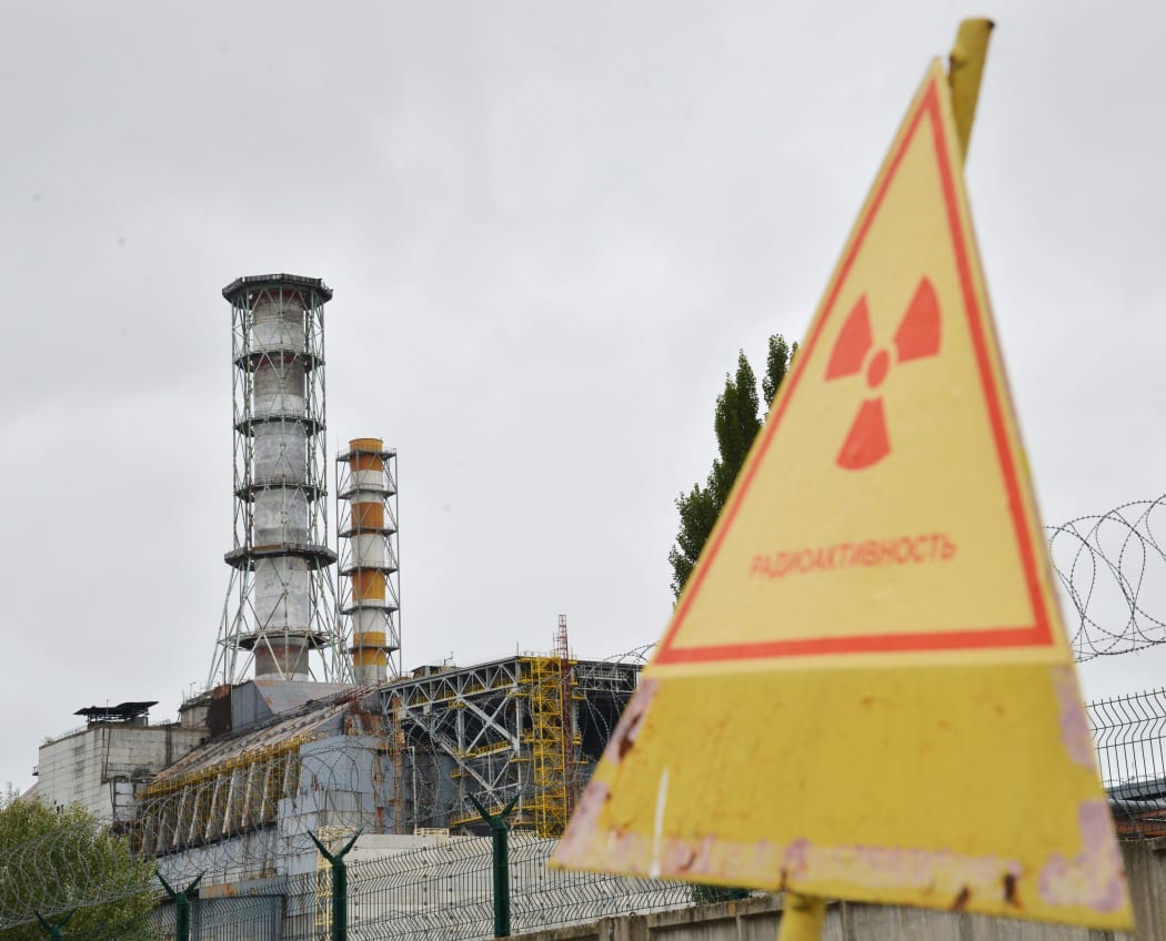 A sign warning of radiation near a shelter and containment area built at Chernobyl's old nuclear power plant.