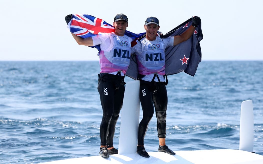 New Zealand's duo Isaac Mchardie and William Mckenzie celebrate  after winning the silver medal at the end of the medal race of the men’s 49er skiff event during the Paris 2024 Olympic Games sailing competition at the Roucas-Blanc Marina in Marseille on August 2, 2024. (Photo by Clement MAHOUDEAU / AFP)