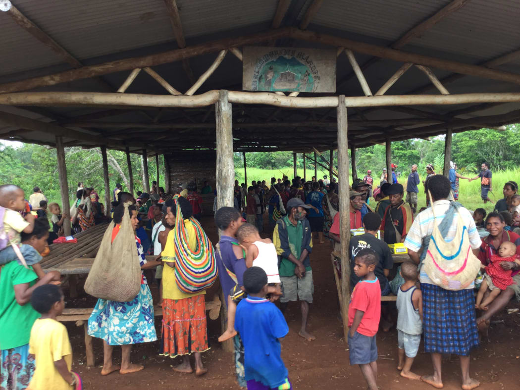 Villagers in PNG's Western Province gather around an empty market place normally filled with fresh produce.