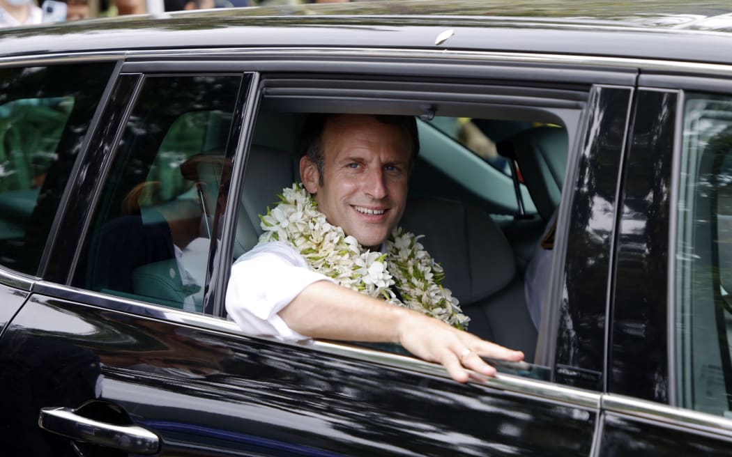 French President Emmanuel Macron smiles from his motorcade as he departs Mo'orea island, French Polynesia on July 27, 2021, and heads back to Tahiti.