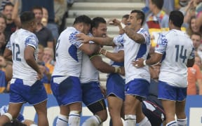 Manu Samoa captain Ofisa Treviranus celebrates with teammates after scoring a try.
