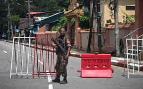 A member of the Myanmar security forces stands by a checkpoint in Yangon on July 19, 2022, on the 75th Martyrs' Day that marks the anniversary of the assassination of independence leaders including general Aung San, father of the currently deposed and imprisoned leader Aung San Suu Kyi. (Photo by AFP)