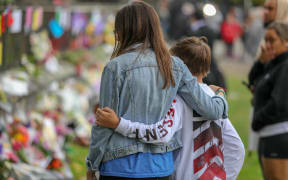 Christchurch Botanic Gardens wall with hundreds of flowers laid in memory of those lost in the mosque shooting