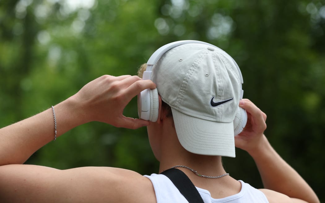 12 August 2023, Bavaria, Würzburg: A young man puts on a pair of headphones. August 12 is International Youth Day. Photo: Karl-Josef Hildenbrand/dpa (Photo by KARL-JOSEF HILDENBRAND / DPA / dpa Picture-Alliance via AFP)