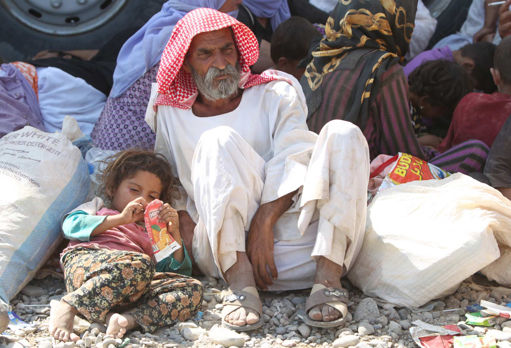 Displaced Iraqis from the Yazidi community rest after crossing the Syrian-Iraqi border.