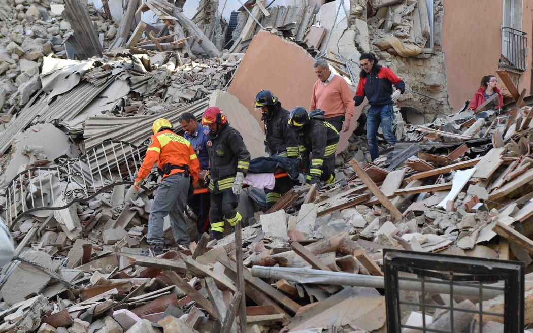 Rescuers free a person from the rubble in Amatrice.