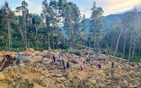 People gather at the site of a landslide in Maip Mulitaka in Papua New Guinea's Enga Province on May 24, 2024. Local officials and aid groups said a massive landslide struck a village in Papua New Guinea's highlands on May 24, with many feared dead.
