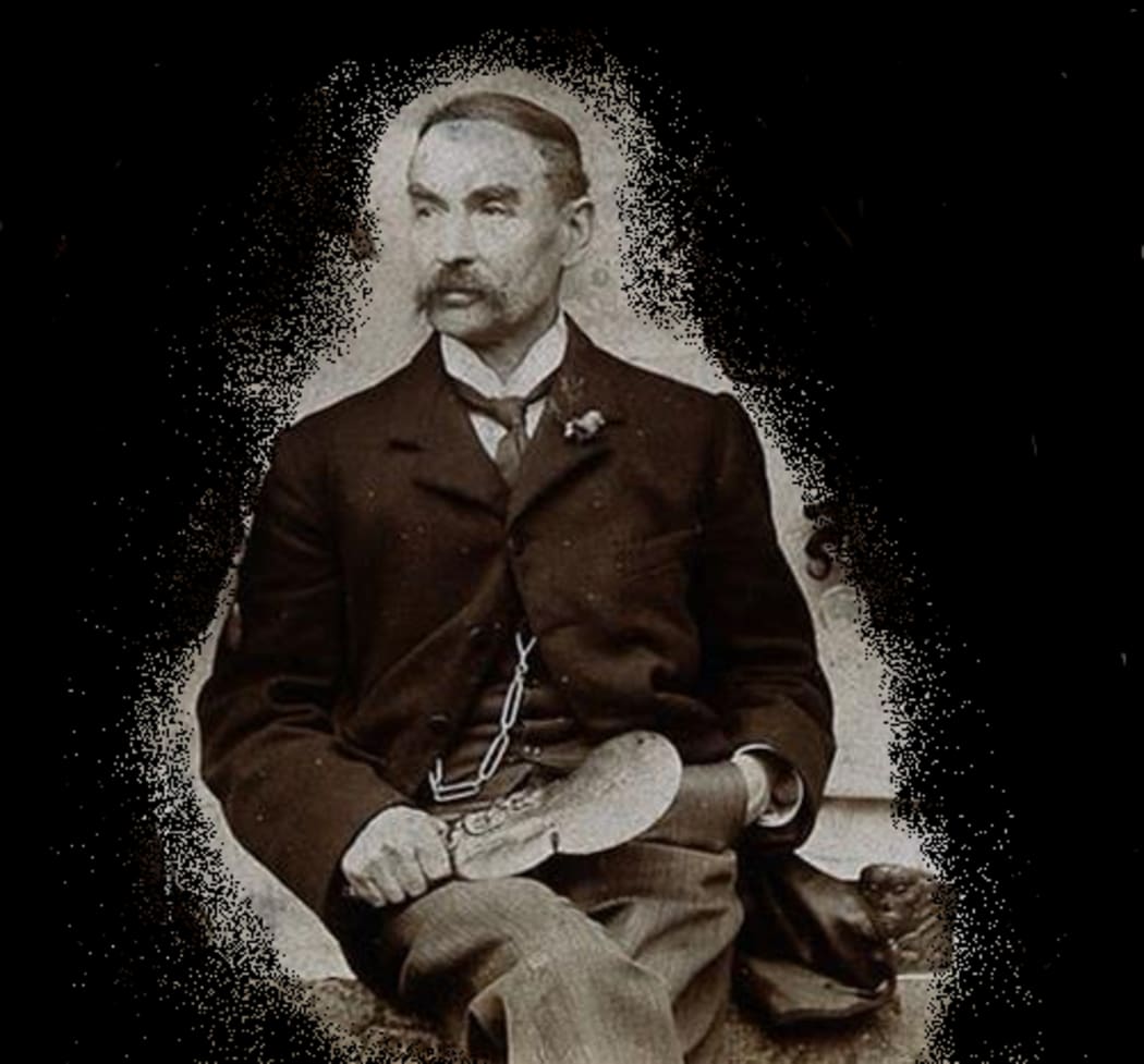 Horatio Robley posing with his collection, the image has been censored to exclude the mokomokai on the wall behind him.