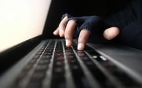 hacker hand stealing data from laptop top down.