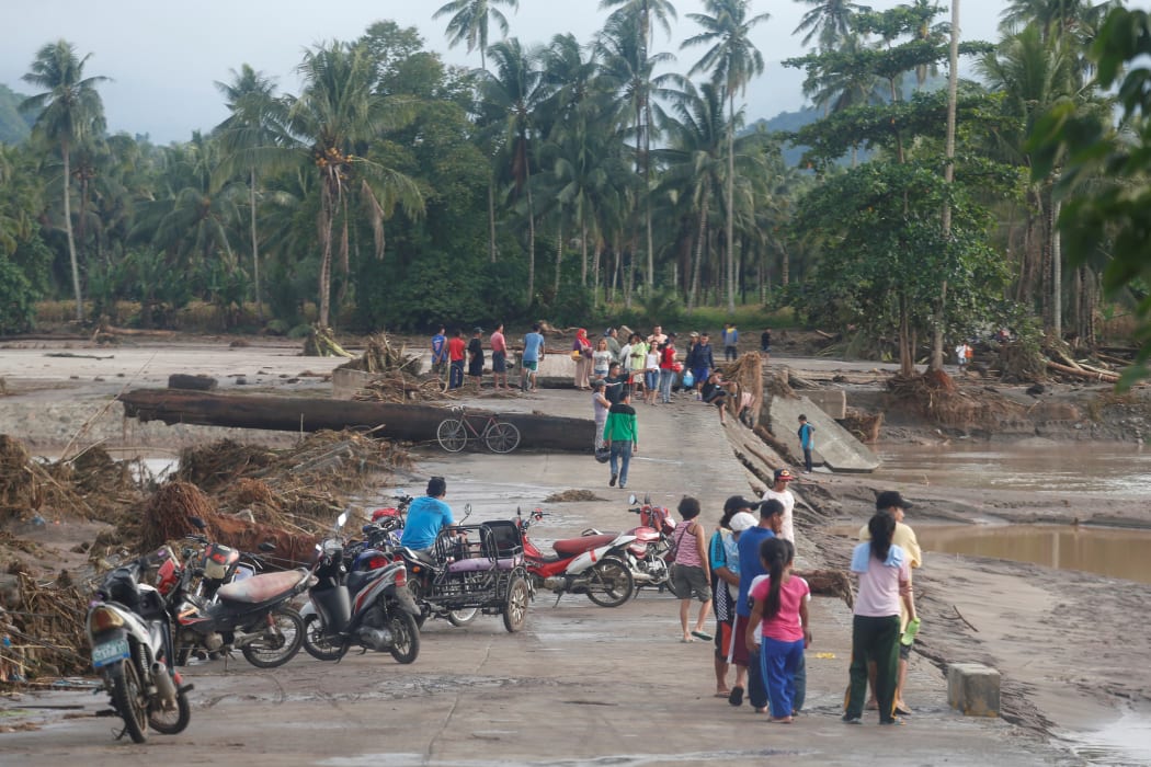 Residents in the flood-hit town of Salvador, Lanao del Norte province, Philippines yesterday after Tropical Storm Tembin swept through the region.