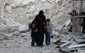 A Syrian family following a reported airstrike on the  al-Muasalat area in the northern Syrian city of Aleppo.