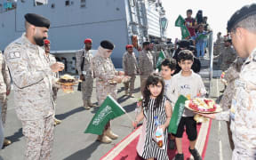 A handout picture provided by the Saudi Press Agency (SPA) on April 22, 2023, shows members of the armed forces passing out chocolates and flowers to Saudi citizens and other nationals upon their arrival in Jeddah, following their rescue from Sudan. - A ship carrying Saudi citizens and other nationals rescued from battle-scarred Sudan arrived in Jeddah, Saudi television said, in the first announced evacuation of civilians since fighting began. (Photo by SPA / AFP) / === RESTRICTED TO EDITORIAL USE - MANDATORY CREDIT "AFP PHOTO / HO / SPA" - NO MARKETING NO ADVERTISING CAMPAIGNS - DISTRIBUTED AS A SERVICE TO CLIENTS ===