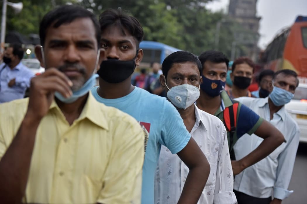 People stand on a line without maintaining social distancing amid coronavirus emergency in Kolkata, India,  on 8 October, 2020.