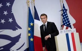 French President Emmanuel Macron stands at a podium at the French Embassy in Washington, DC, on 30 November, 2022.