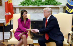 US President Donald Trump shakes hands with Nikki Haley, the United States Ambassador to the United Nations in the Oval office.