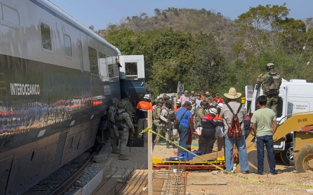 Mexican Army soldiers and Civil Protection members rescue passengers from the Interoceanic train that derailed in the Asuncion Ixtaltepec area on the route to Oaxaca, Mexico, on December 28, 2025. At least 20 people were injured this Sunday after a train crashed in the state of Oaxaca, in southern Mexico, authorities reported. (Photo by Rusvel RASGADO / AFP)