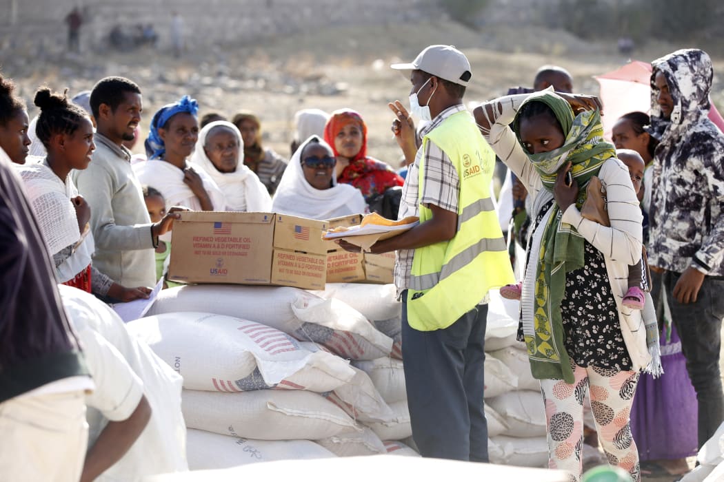 Tigray people, who fled due to conflicts and taking shelter in Mekelle city of the Tigray region, in northern Ethiopia, receive the food aid distributed by United States Agency for International Development on 8 March, 2021.