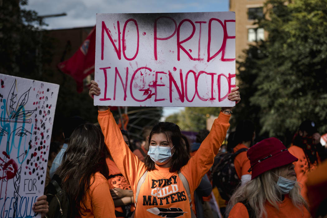 A woman holds a placard during the "Every Child Matters" march to mark the first National Day for Truth and Reconciliation in Montreal, Canada on September 30, 2021.