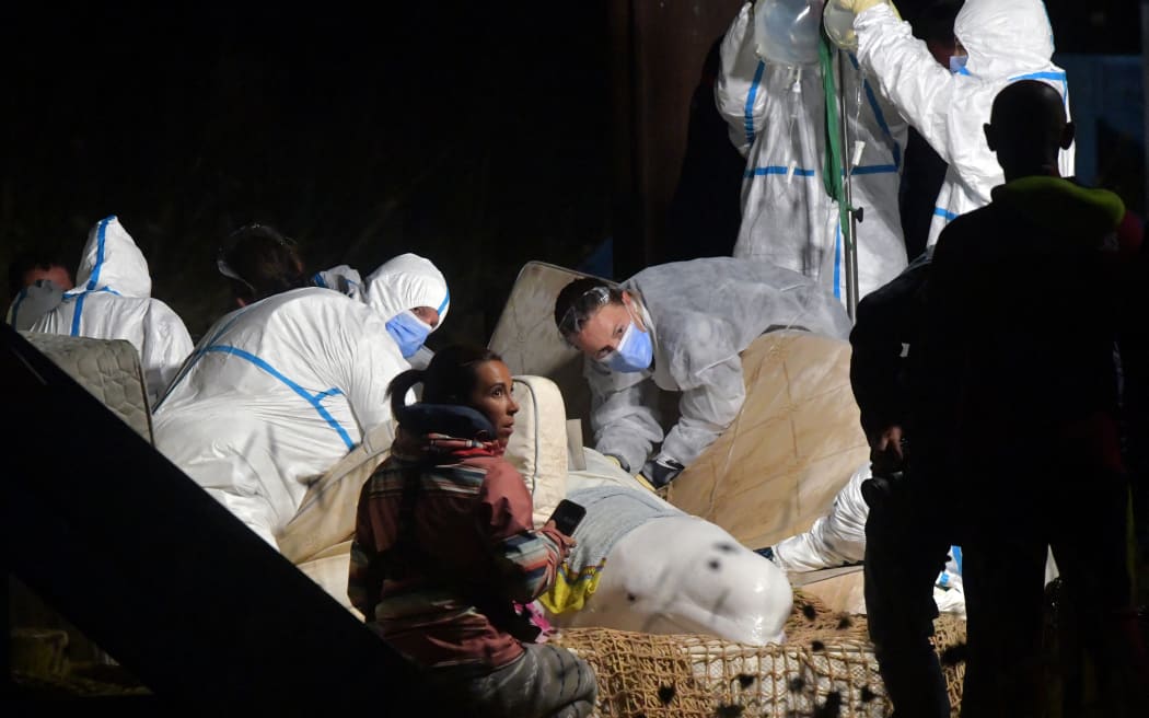 Veterinarians take care of a beluga whale that was stranded in the River Seine at Notre Dame de la-Garenne, northern France, on August 9, 2022. - French marine experts launched an ambitious operation on August 9 to rescue an ailing beluga whale that swam up the Seine river, to return it to the sea. The four-metre (13-foot) cetacean, a protected species usually found in cold Arctic waters, was spotted a week ago heading towards Paris, and is now some 130 kilometres inland. (Photo by JEAN-FRANCOIS MONIER / AFP)