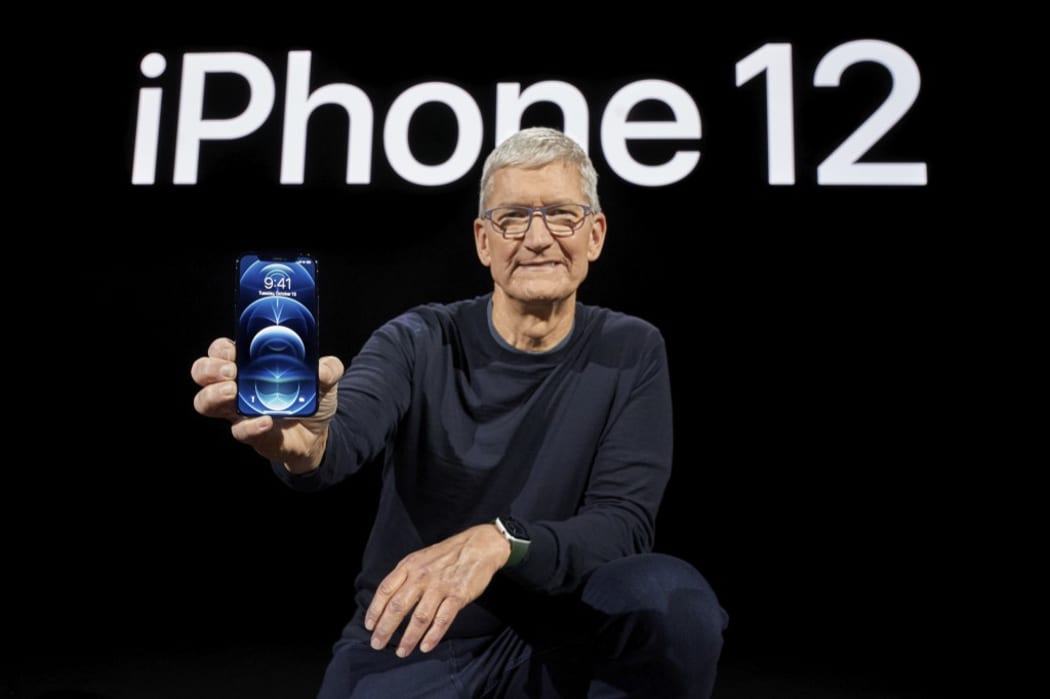 In this photo released by Apple, Apple CEO Tim Cook holds up the all-new iPhone 12 Pro.