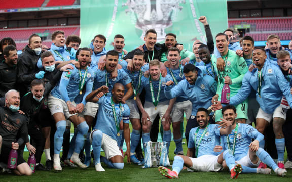 Manchester City players celebrate with the trophy after winning the English League Cup final against Tottenham Hotspur at Wembley Stadium, northwest London on April 25, 2021.