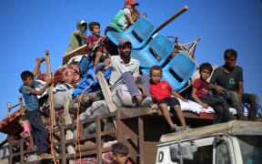 Displaced Palestinians move with their belongings southwards on a road in the Nuseirat refugee camp area in the central Gaza Strip following renewed Israeli evacuation orders for Gaza City on September 16, 2025. Israel launched its long-anticipated ground assault on Gaza City at dawn on September 16, a day after winning backing from its top ally the United States despite mounting international alarm. (Photo by Eyad BABA / AFP)