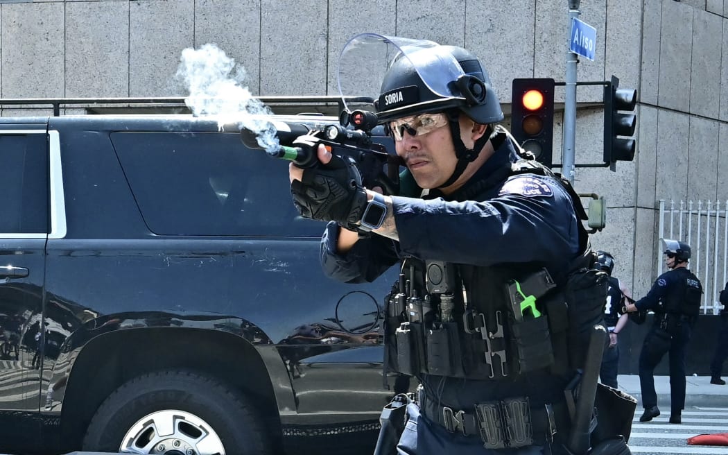 Law enforcement clashes with demonstrators outside the Metropolitan Detention Center, MDC, in downtown Los Angeles, California on June 8, 2025. US President Donald Trump deployed 2,000 troops on June 7 to handle escalating protests against immigration enforcement raids in the Los Angeles area, a move the state's governor termed "purposefully inflammatory." Federal agents clashed with angry crowds in a Los Angeles suburb as protests stretched into a second night Saturday, shooting flash-bang grenades and shutting part of a freeway amid raids on undocumented migrants, reports said. (Photo by Frederic J. Brown / AFP)