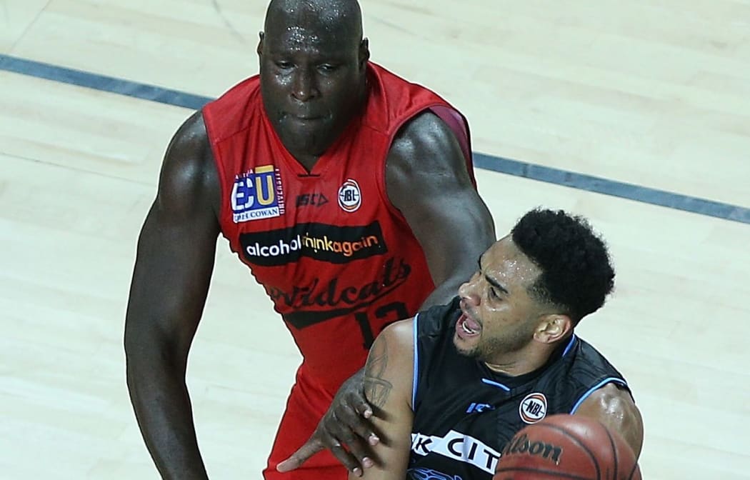 Perth player Nate Jawai defends Breakers guard Corey Webster
