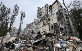 Ukrainian emergency work amid the rubble of a residential building after an air attack in Kyiv on July 31, 2025, amid the Russian invasion of Ukraine. Russian strikes on Kyiv killed at least six people, officials said on July 31, 2025, as Moscow claimed the capture of a town that had been a key stronghold for the Ukrainian army in the east of the country. Drones and missile strikes hit at least 27 locations in Kyiv in the early hours, city officials said. (Photo by Sergii VOLSKYI / AFP)
