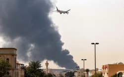 An Emirates aircraft prepares for landing as a smoke plume rises from an ongoing fire near Dubai International Airport in Dubai on March 16, 2026. Flights were gradually resuming at Dubai airport on March 16, previously the world’s busiest for international flights, the airport operator said, after a “drone-related incident” sparked a fuel tank fire nearby, as Iran kept up its Gulf attacks.