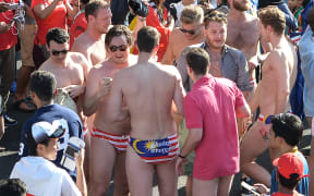 Spectators - reported to be Australian tourists - with swimwear featuring the Malaysian flag during the Formula One Malaysian Grand Prix in Sepang on 2 October.