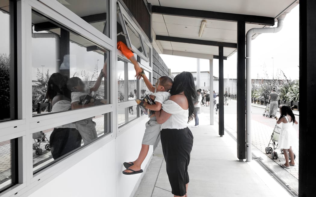 "Bye bye Dadda" a boy reaches for one last goodbye to his father before heading outside the prison walls