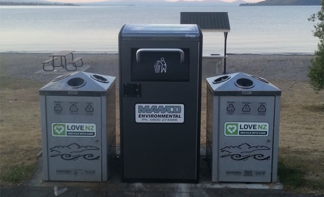 A Bigbelly bin, flanked by two recycling bins