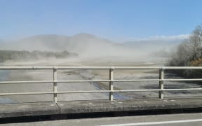 Clouds of dust rise off the Waiapu River and surrounds.