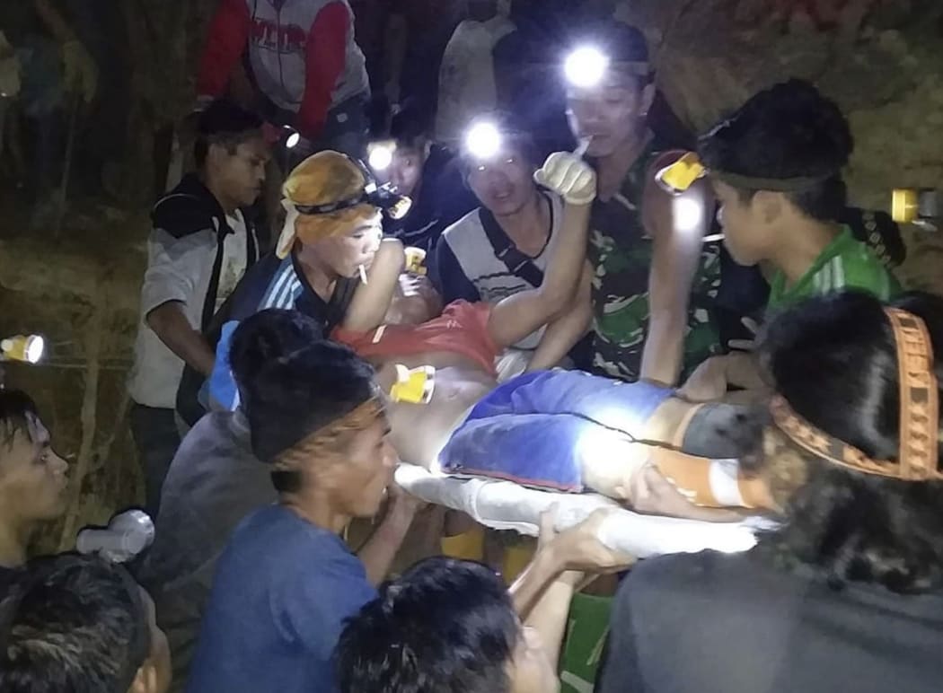 In this undated photo released by Indonesian Search And Rescue Agency (BASARNAS) rescuers evacuate a survivor from a collapsed gold mine in Bolaang Mongondow, North Sulawesi, Indonesia.