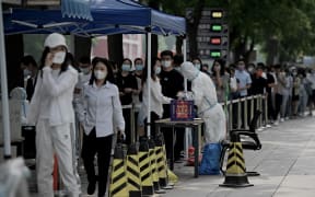 People queue at a swab collection site to test for Covid-19 in Beijing on June 13, 2022.