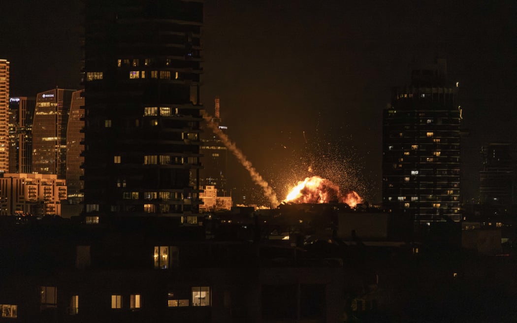A fireball lights the sky following a missile strike on Tel Aviv on February 28, 2026. The United States and Israel launched strikes against Iran on February 28, with Israel's public broadcaster reporting that the Iranian supreme leader had been targeted, as the Islamic republic retaliated with barrages of missiles at Gulf states and Israel. (Photo by JOHN WESSELS / AFP)