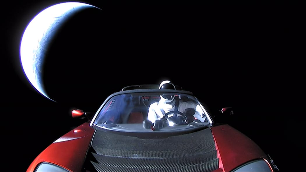 3290409 02/08/2018 SpaceX CEO Elon Musk's own car, red Tesla Roadster cabrio, entered into orbit by the Falcon Heavy launcher, with a dummy wearing a spacesuit at the steering wheel, in outer space.