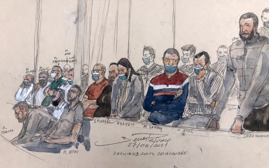 Court sketch shows Salah Abdeslam (standing at right) and 13 other defendants in Paris' criminal court during the trial of the November 2015 attacks.