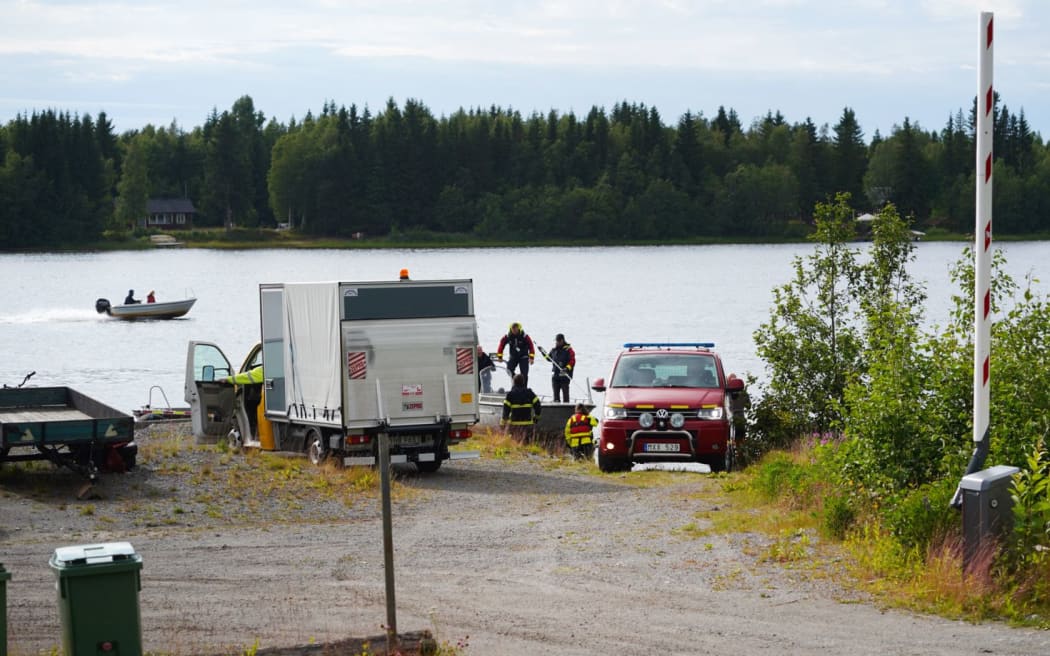 An emergency services boat with wreckage parts arrives at a small harbor near the accident site outside Umea, Sweden where a small sports aircraft with nine people on board has crashed and died.