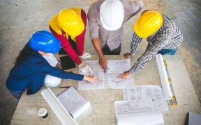 Engineer and foreman meeting at site with blueprint